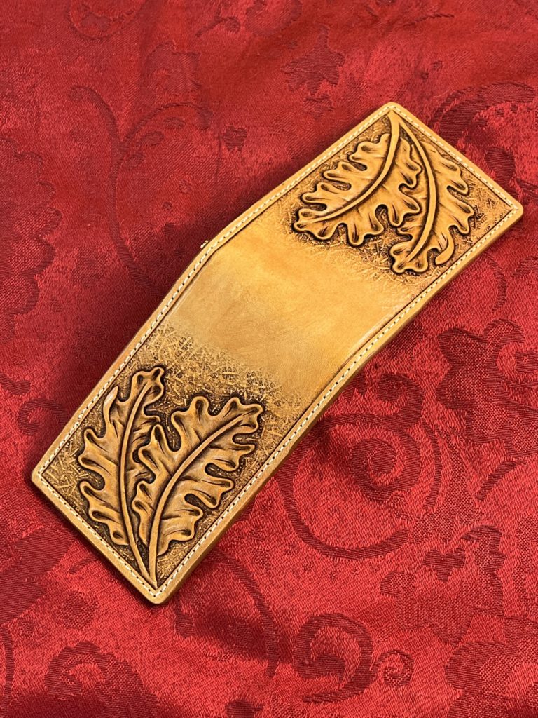 Leather money clip with oak leaf carving