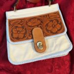 A soft leather handbag with a carved front flap.