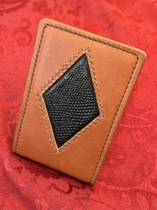 A leather money clip with a black lizard skin inlay.