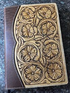 A custom leatherwork notebook with floral carving.